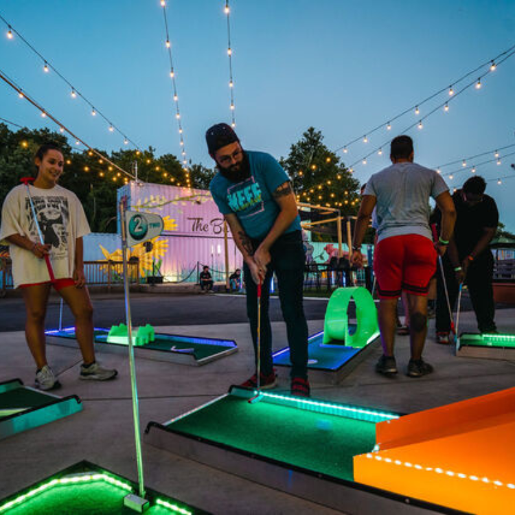 people playing LED mini golf