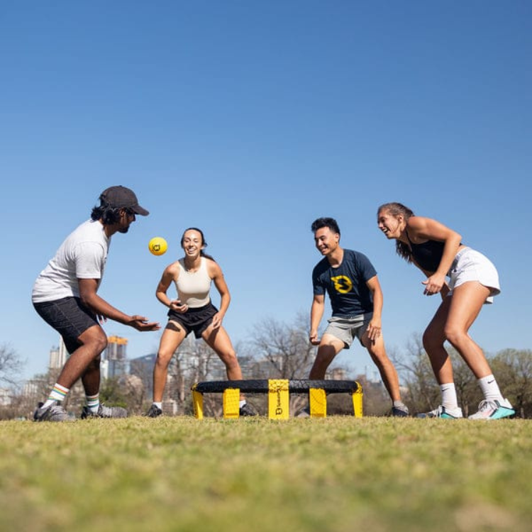 four players playing spikeball