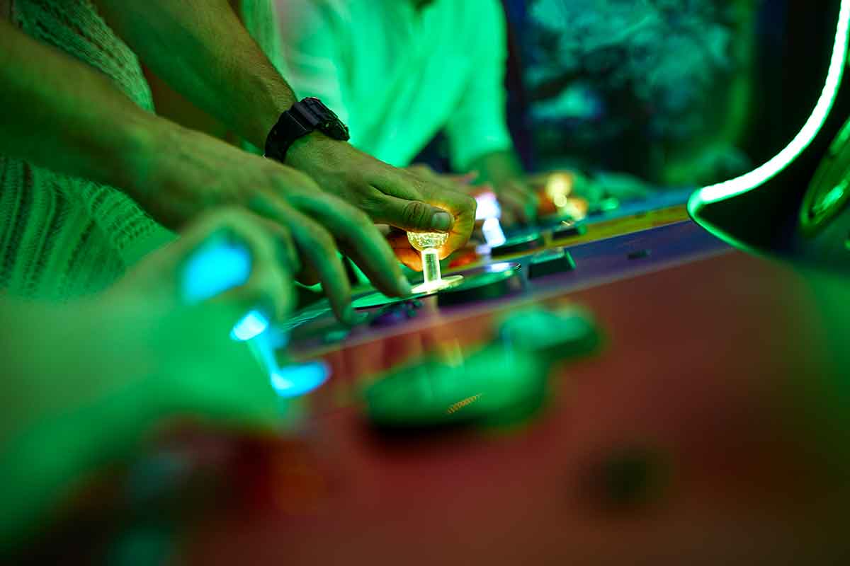 close-up-of-friends-playing-in-an-amusement-arcade